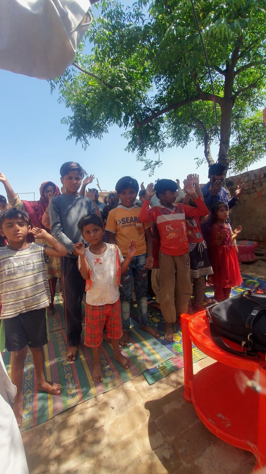 Children worshipping with raised hands at outdoor Pakistan ministry